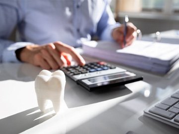 Dentist calculating the cost of dental implants in Norwood