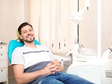 Man smiling in dental chair wearing t-shirt