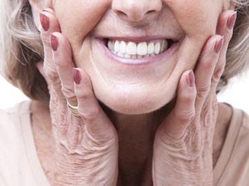 closeup of woman smiling with dentures in Norwood