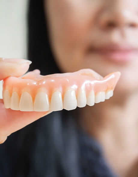 closeup of woman smiling with dentures in Norwood