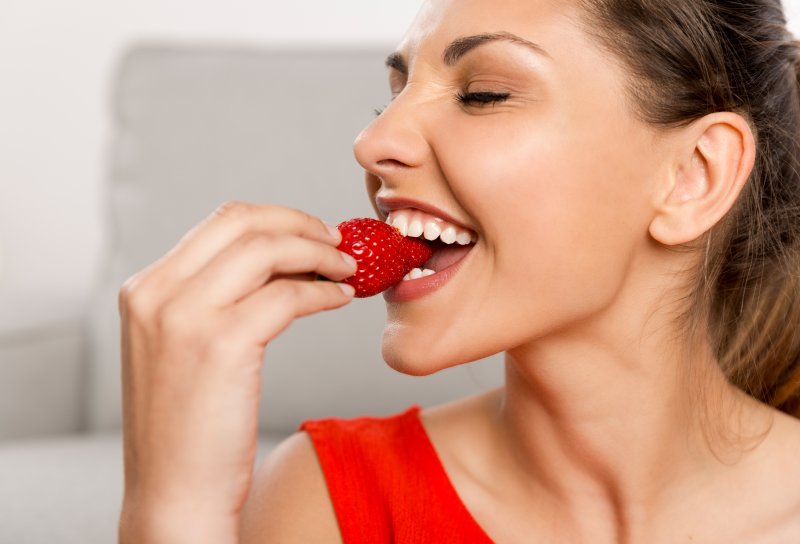 woman eating strawberry after teeth whitening