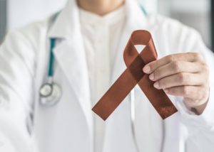 a dentist holding an oral cancer awareness ribbon