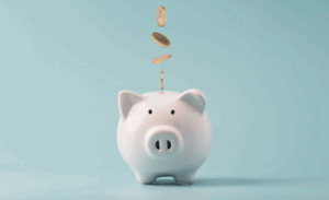 Coins dropping into a white piggy bank